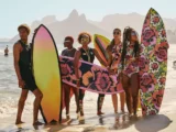 Kolekcja Rip Curl x Farm Rio - grupa ludzi ubrana w kwiatowe stroje do surfingu trzymający kolorowe deski surfingowe